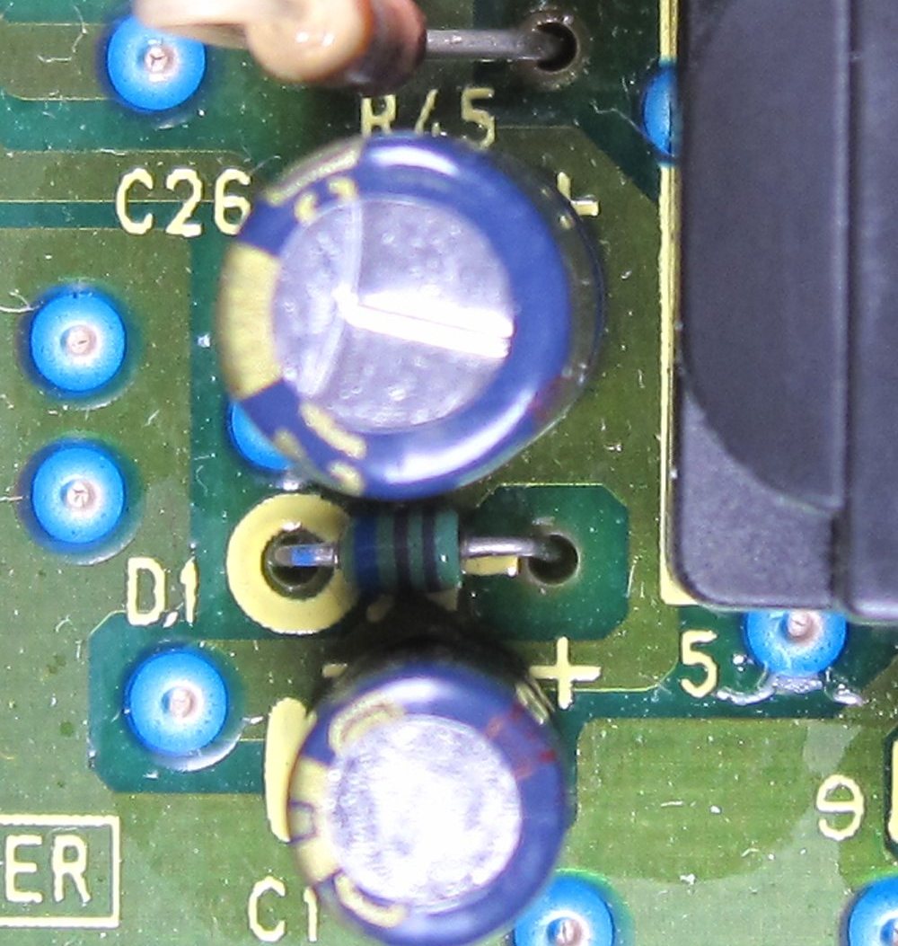 The same spot on the board with new long-life capacitors fitted flat to the board