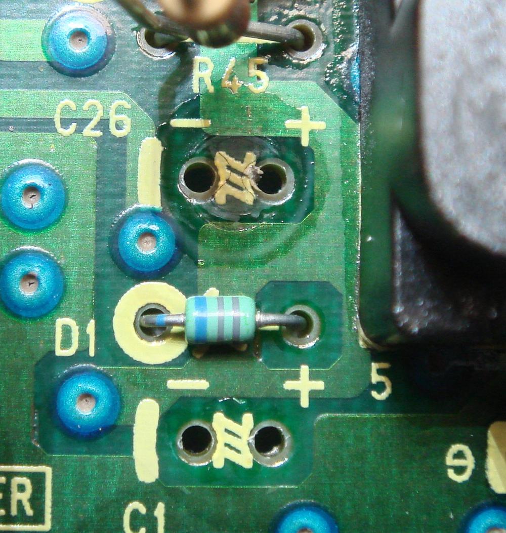Circuit board pads coated in dark electrolyte residue, before cleaning