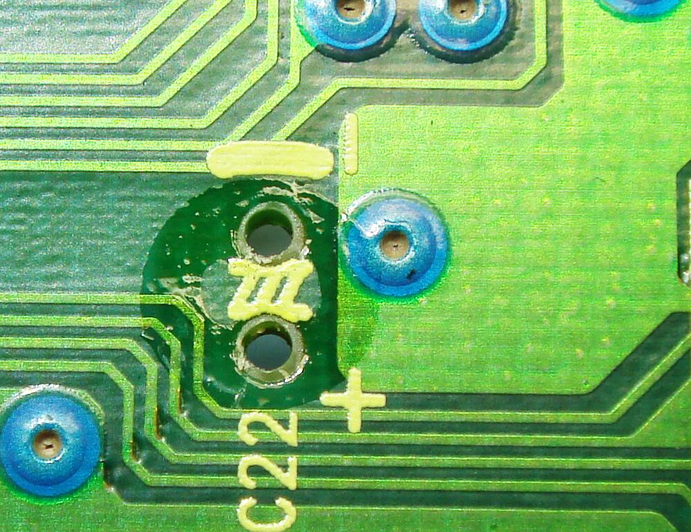 Brown electrolyte residue ringing the solder pads under a capacitor that has been removed from a circuit board